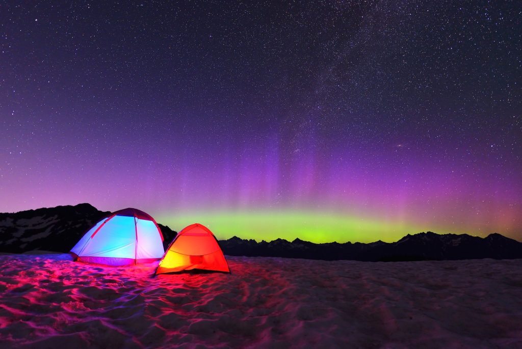 Aurora Borealis And Tents On Snow Mountain