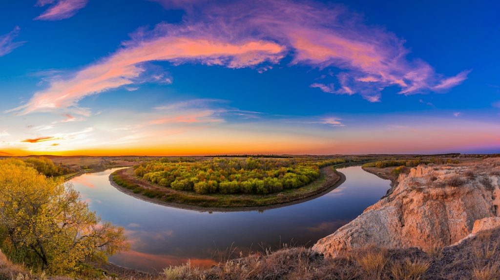 A panoramic view of Badlands National Park against a sunset.
