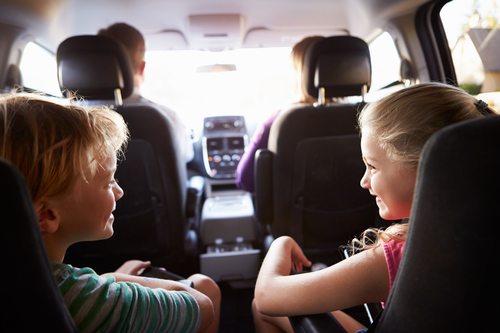 Children In Back Seat Of Car On Journey With Parents