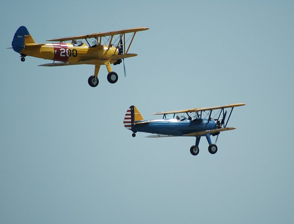 yellow and blue antique airplanes flying in the air