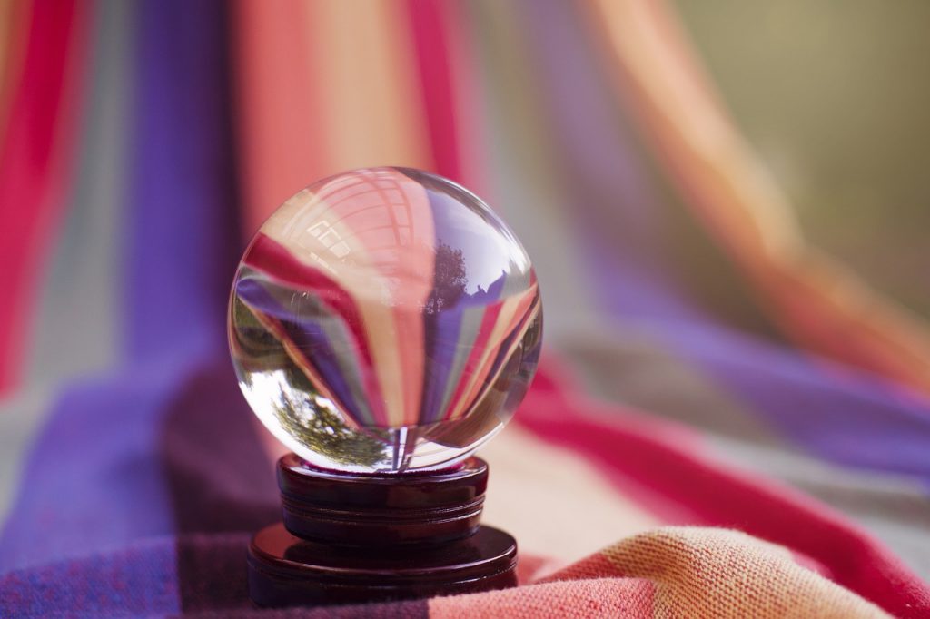crystal ball sitting on top of a colorful striped drape