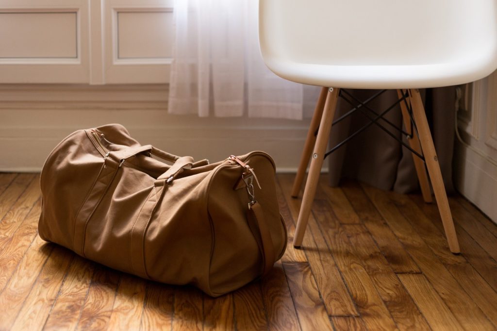 small brown duffel bag or suitcase on a wooden floor